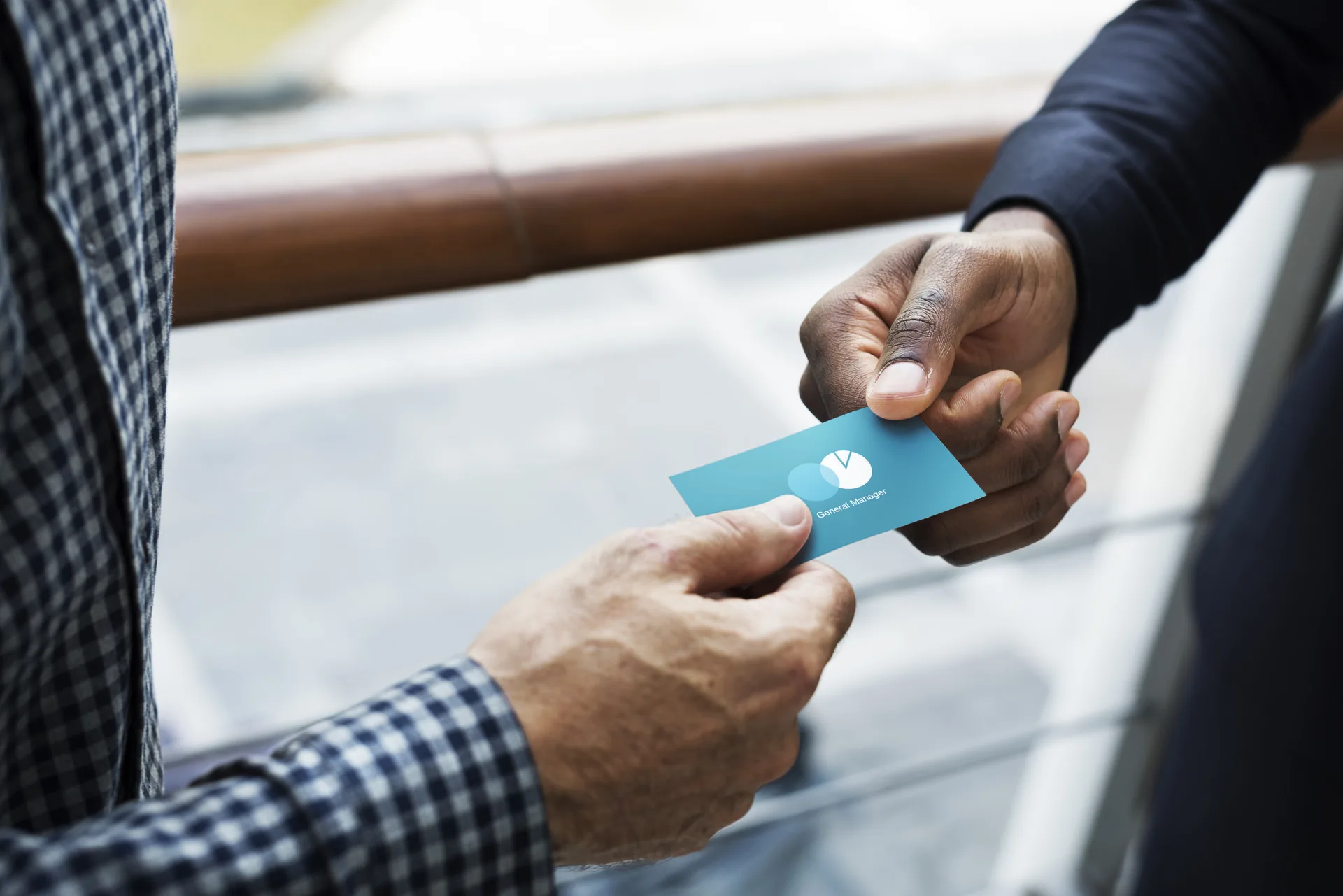 Business professional handing a branded business card to a colleague